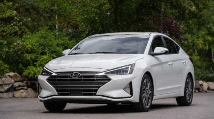A customer reviews a car finance agreement at a dealership desk, with a calculator and keys on the table