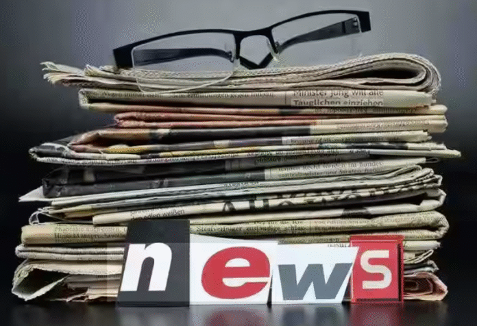 A person reading a regional-language e-paper on a smartphone next to a folded print newspaper.